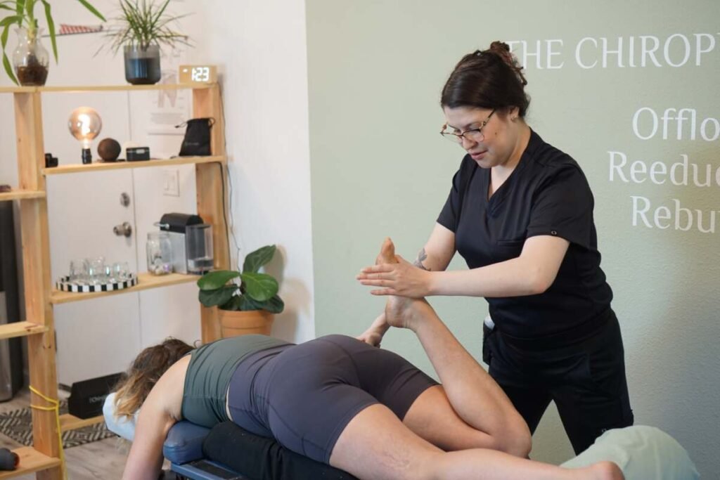 Massage therapist performing an assisted leg and hamstring stretch on a patient at The ChiropractOrr