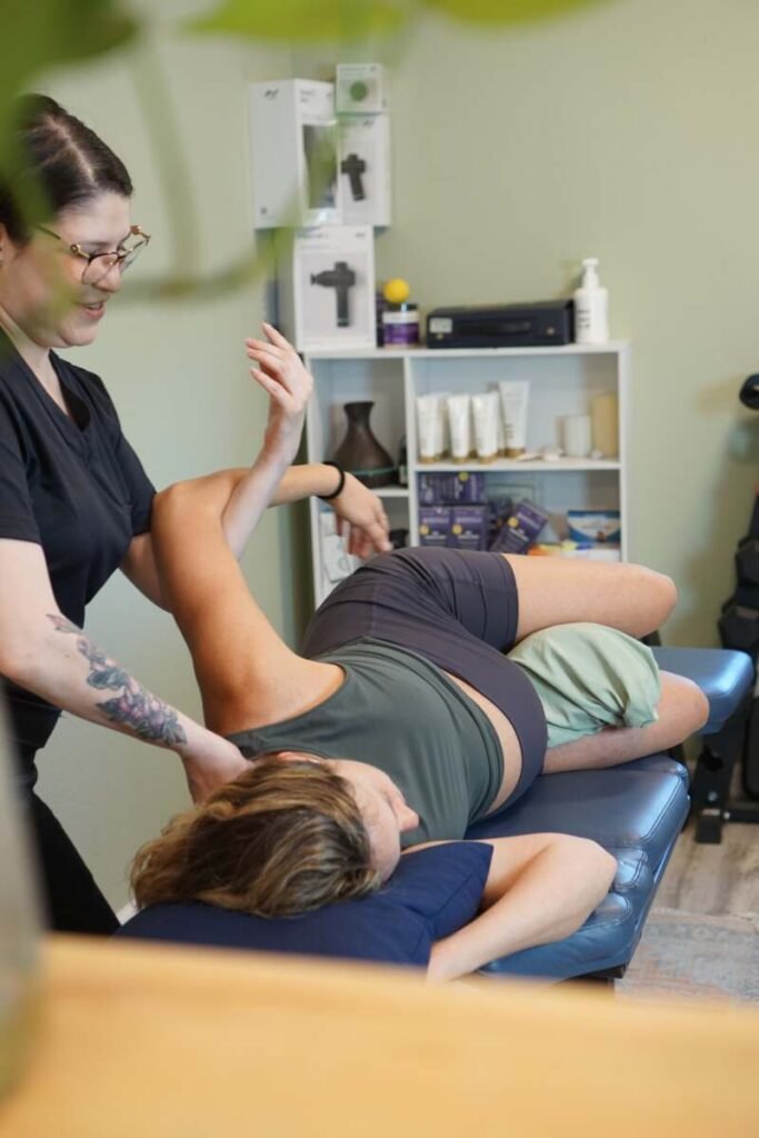 Therapist performing a supported prenatal massage and shoulder stretch on a side-lying patient at The ChiropractOrr